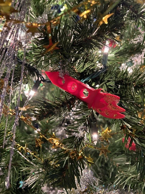A red toy on a treeDescription automatically generated